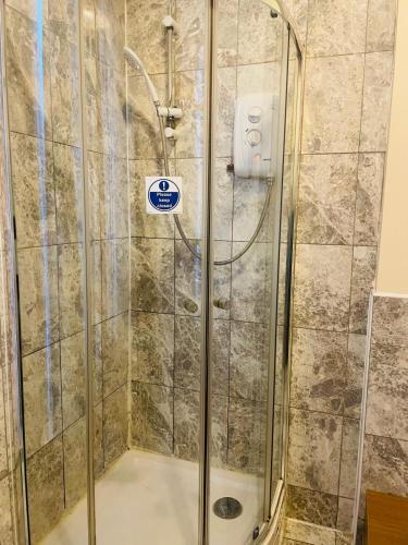 a shower with a glass door in a bathroom at Eurobar & Hotel in Oxford