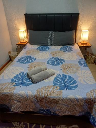 a bed with two pillows on it with two lamps at Sentirse en casa in Puerto Iguazú