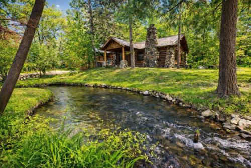 a log cabin with a stream in front of it at Steps to Beach-Hot Tub-Fireplace-Northern Original in Traverse City