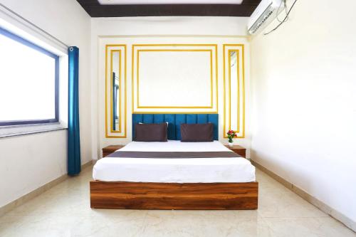 a bedroom with a large bed with a blue headboard at The Prem Royal Resort & Hotel in Dāūd Khān