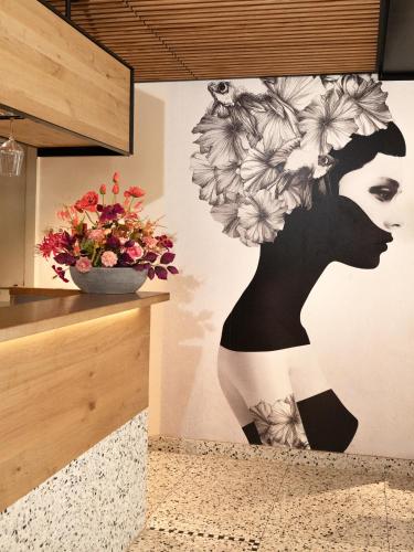 a mural of a woman with flowers on a wall at Auberge De Moerse Hoeve in De Moer