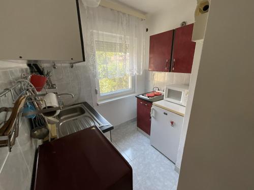 a small kitchen with a sink and a microwave at Anna Vendégház in Harkány
