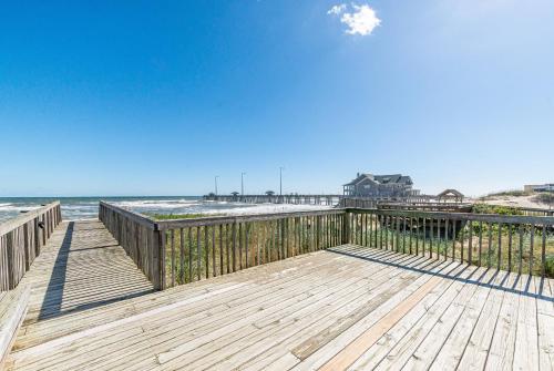 a wooden boardwalk leading to a beach with the ocean at Dune Diamond - Nags Head MP 16.5, Oceanfront, Elevator, Heated Pool, Hot Tub, Pets OK, Flex Stays in Nags Head