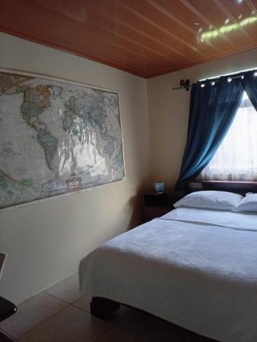 a bedroom with a bed and a map on the wall at Casa morfo in Bijagua