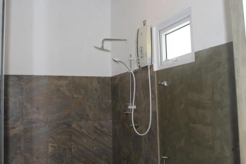 a shower in a bathroom with a window at Kadulla Resort in Habarana