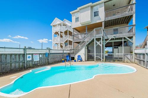 a swimming pool in front of a building at Shell Town – Nags Head MP 16, Ocean View, 360 Yds to Beach, Pool, Hot Tub, Flex Stays in Nags Head
