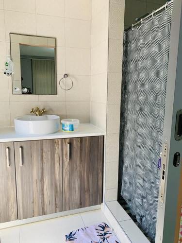 a bathroom with a sink and a mirror at Logo Luxury Guesthouse in Windhoek
