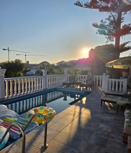 a balcony with benches and a sunset in the background at Villa Don Giovanni Fuengirola, Piscina Privada y vistas al mar y a la Montaña in Fuengirola