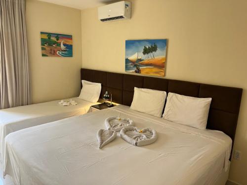 a hotel room with two beds with a heart on the bed at Vizinho dos Parapente - Novo Luxo apartamento in Canoa Quebrada