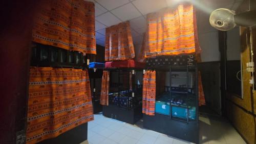 a store with orange curtains and bottles of wine at Sunny hostel garden in Pai