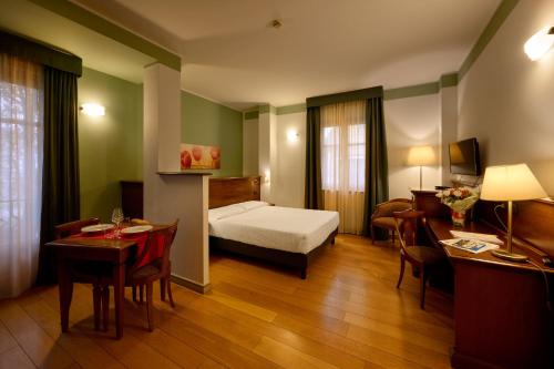 a hotel room with a bed and a table and chairs at Hotel & Residence Torino Centro - Stazione Porta Susa in Turin