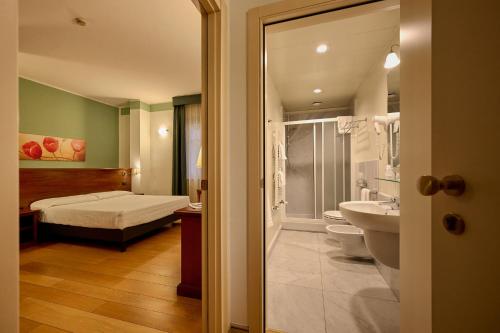 a bedroom with a bed and a bathroom with a sink at Hotel & Residence Torino Centro - Stazione Porta Susa in Turin