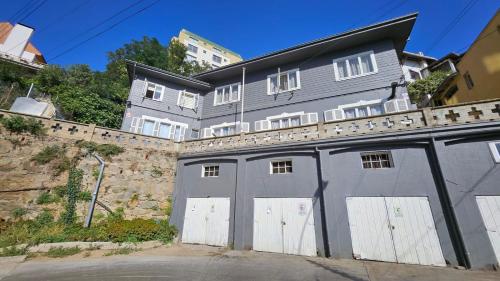 a gray building with white doors and a fence at Hostel Varas in Viña del Mar
