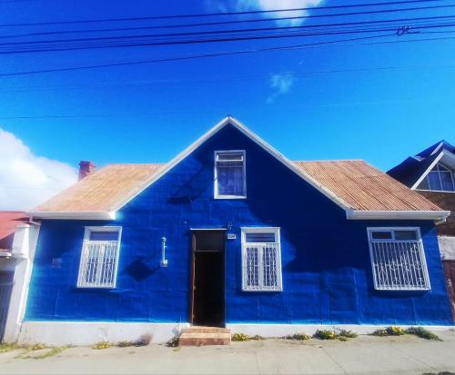 a blue house with white windows and a door at Central House in Punta Arenas