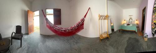 a room with a hammock in the middle of a room at Vila Manguita Suíte Manguita in São Gonçalo do Amarante