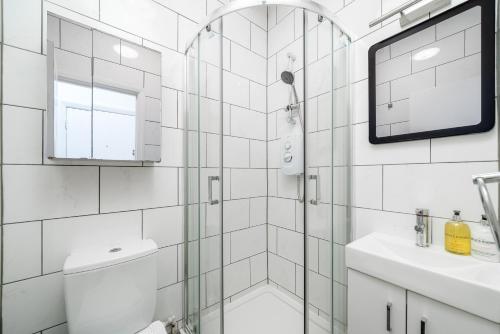 a white bathroom with a shower and a sink at Carnaby & Oxford Street, Elegante Apartamento Soho in London