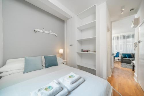a bedroom with a white bed with towels on it at Carnaby & Oxford Street, Elegante Apartamento Soho in London