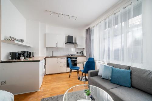 a living room with a couch and a kitchen at Carnaby & Oxford Street, Elegante Apartamento Soho in London