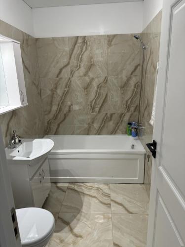 a bathroom with a tub and a toilet and a sink at Pollux Residence Militari Ap 81 in Bucharest