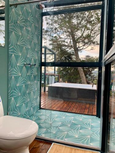 a bathroom with a toilet and a glass door at Kamarí Glamping in San Francisco