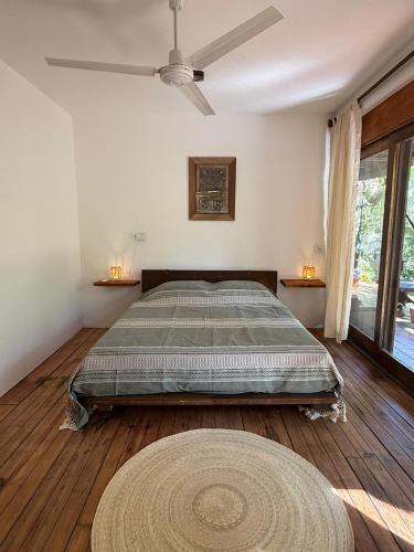 a bedroom with a bed and a large window at La baxada mazunte in Mazunte