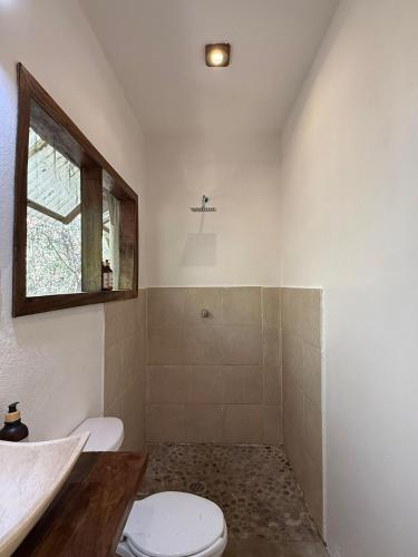 a bathroom with a toilet and a sink and a window at La baxada mazunte in Mazunte