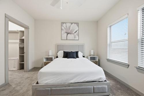 a white bedroom with a bed and two windows at Chisholm Trace 1236 I Spacious 1 Bed 1 Bath in Cleburne
