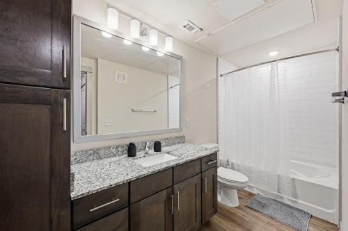 a bathroom with a sink and a toilet and a mirror at Chisholm Trace 1236 I Spacious 1 Bed 1 Bath in Cleburne