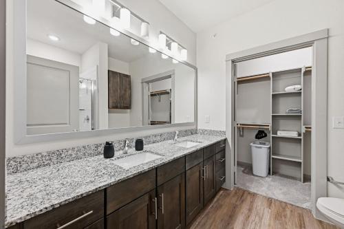 a bathroom with two sinks and a large mirror at Unit 232 Comfy 2BR 2BA Retreat in Cleburne