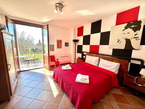a bedroom with a red bed with two towels on it at Villa Rita - Rooms&Art in Case Ghisiolo