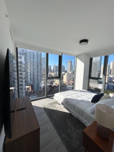 a bedroom with a large bed and large windows at Miami-Brickell Luxury 2BR-2BATH with skyline VIEWS - walking distance to KASEYA-HEAT ARENA & BAYSIDE - Port of MIAMI cruise ships in Miami