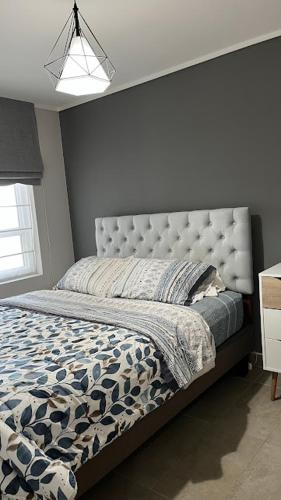 a bedroom with a large bed with a large headboard at Depa Céntrico con estacionamiento in Temuco