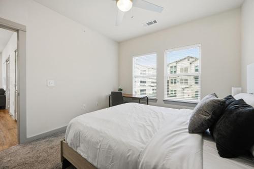 a white bedroom with a bed and two windows at Chisholm Trace 327 Relaxing 2BD 2BA in Cleburne