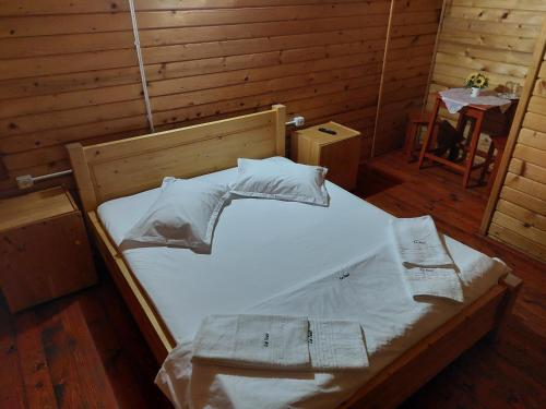 a bed with white sheets and pillows in a room at La Tavi casute tip camping in Murighiol