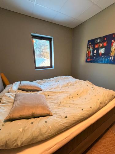a large bed in a bedroom with a window at Lofoten Viewpoint 13 in Vestvågøya