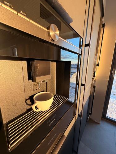 a coffee cup is sitting in a microwave at Lofoten Viewpoint 13 in Vestvågøya