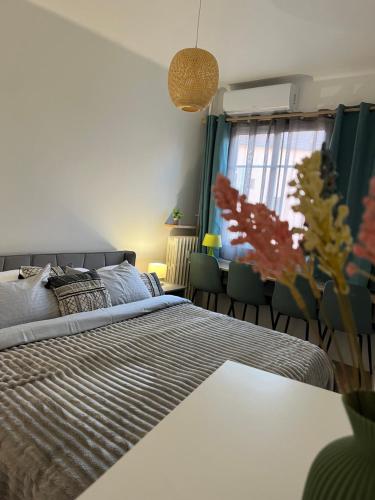 a bedroom with a bed and a table and a window at De Gaulle 2 pièces Сentral Appartement in Cagnes-sur-Mer