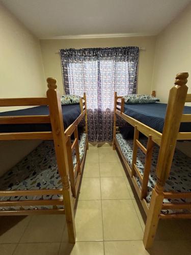 a bedroom with two bunk beds and a window at Casa do Rio in Morretes