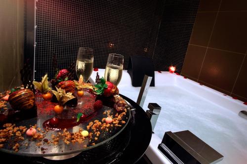 フィゲイラ・ダ・フォズにあるスウィート アトランティック ホテル & スパのシャンパングラス2杯と食べ物が置かれたテーブル