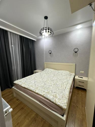 a bedroom with a bed and a chandelier at Ander Tower in Stantsiya Batumi-Passazhirskaya