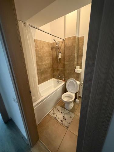 a bathroom with a toilet and a tub and a sink at Resident aparments two bed with balcony in Bucharest