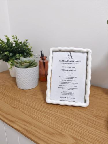 a sign on a counter with two potted plants at Garibaldi Apartment Sanremo La Piazzetta in Sanremo