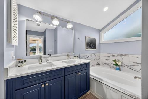 a bathroom with two sinks and a tub and a large mirror at 4922 Turtle Point in Kiawah Island