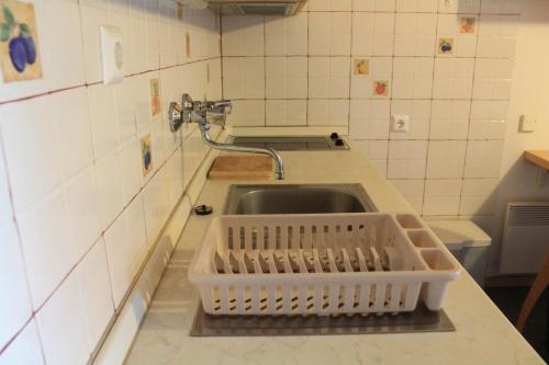 a kitchen sink with a basket on the counter at Apartments Rogla in Zreče