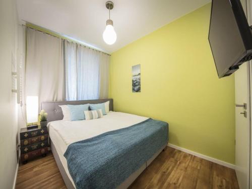 a bedroom with a bed with a yellow wall at Strandburg "Azurblau" 01 c in Burgtiefe auf Fehmarn 