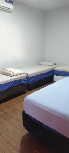 two beds sitting next to each other in a room at Pousada santa Clara in Matão