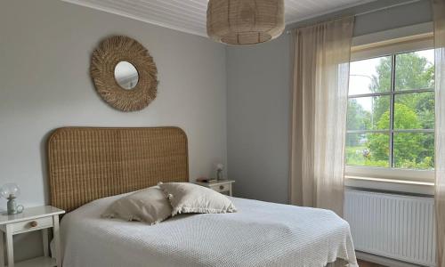 a bedroom with a bed with a mirror and a window at Cozy big villa in Hanko in Hanko