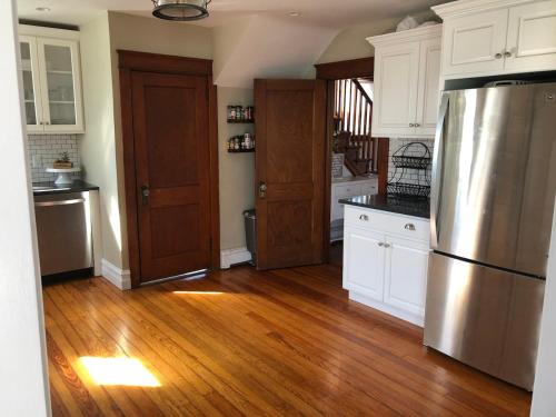 a kitchen with white cabinets and a stainless steel refrigerator at Comfortable Craftsman Getaway in Lancaster