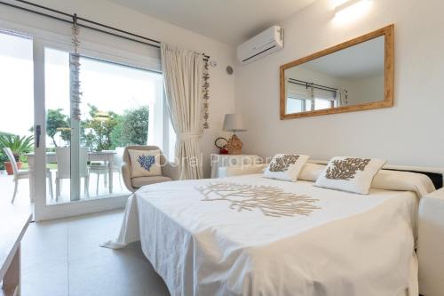 a bedroom with a bed and a mirror on the wall at Suite Rea Beachfront - Giardino & Spiaggia Privata - by Coral Property in Porto Cervo