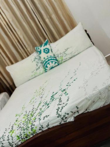 a bed with white sheets and pillows on it at Nathalie Villa in Anuradhapura